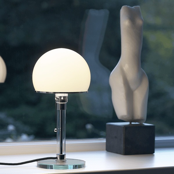 La lampe bauhaus WG24 de Wilhelm Wagenfeld allumée, répondant une lumière douce diffuse